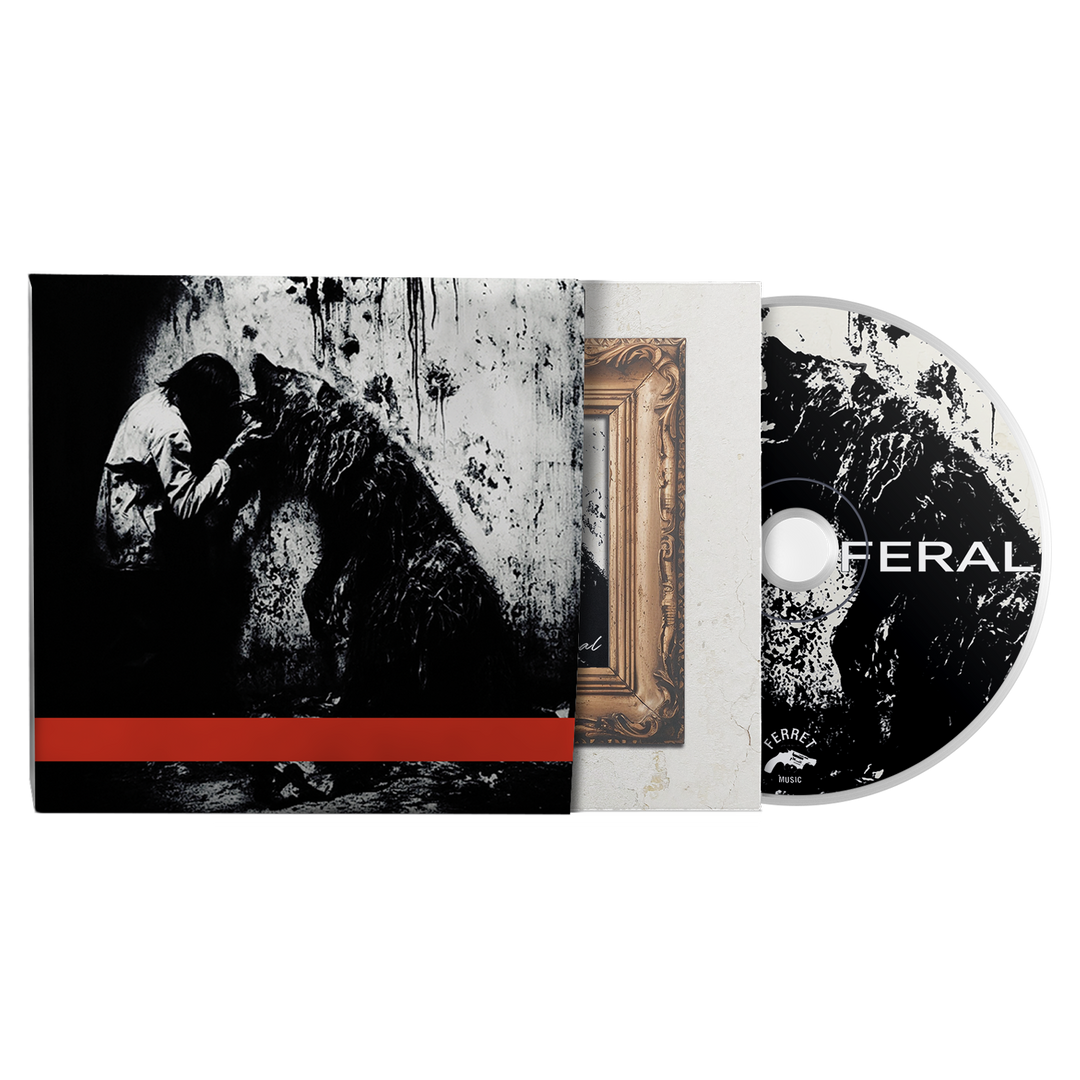 Feral - Deluxe CD case showing a black-and-white image of a person kneeling before a wolf, partially obscured by a red band, with the matching disc displaying a black-and-white graphic and the word FERAL next to the bonus songs.
